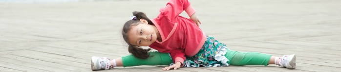 a girl lying on the ground with another girl standing on her back