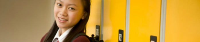a woman smiling in front of a yellow wall
