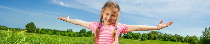 a girl with her arms out in a field